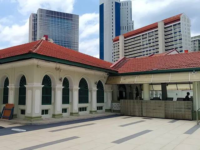 The exterior of a colonial-era mosque against a city skyline