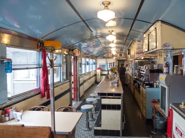 The interior of a diner, showing booth seating and counter stools.