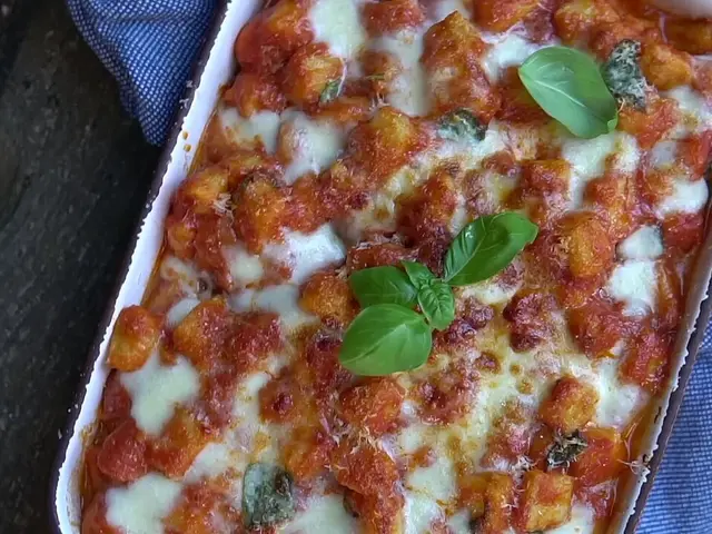 A plate of gnocchi alla sorrentina with tomato sauce and cheese.