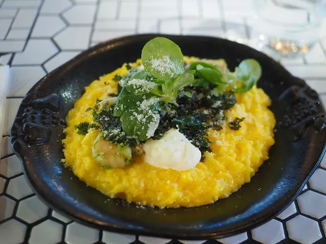 A plate of saffron risotto topped with shrimp.