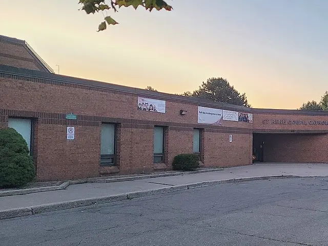 The brick entrance of St. René Goupil Catholic School, with the school's name on a sign above the doorway.