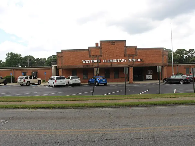 The brick entrance of Westside Elementary School, with the school's name lettered above the doors and cars parked out front.
