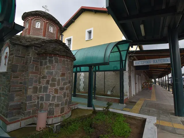 The exterior of a small white church building beside a railway station platform.