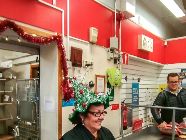 A staff member working at the cashier counter of a grocery store.