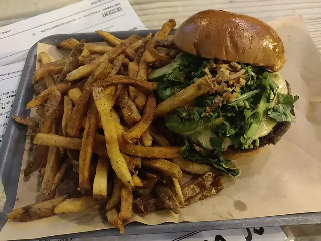A cheeseburger served with a side of crinkle-cut fries.