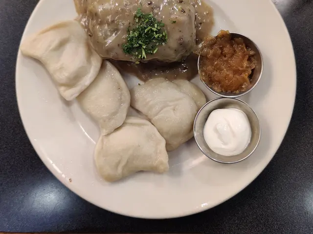 A mixed vegetarian plate with pierogi and stuffed cabbage at a restaurant.