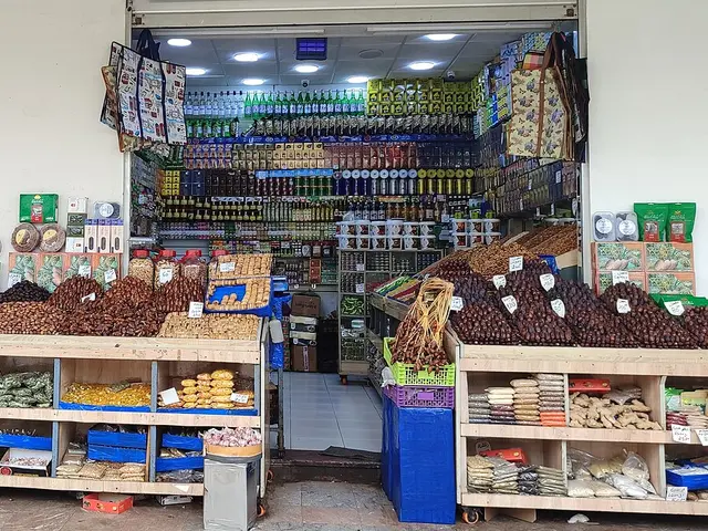 Interior of a grocery store in the Rabat Medina, Morocco, with stacked displays of dates, nuts, and shelves of packaged goods.