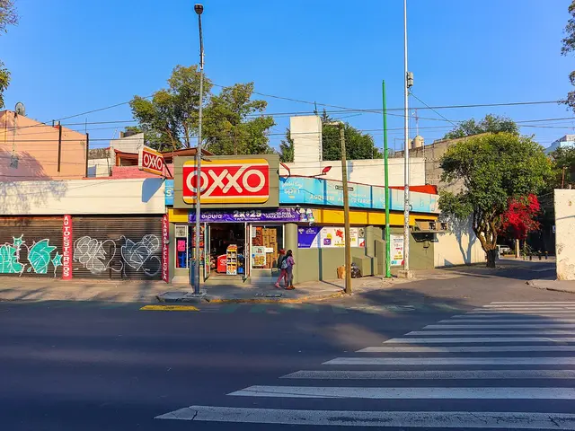 Oxxo convenience store on a street corner, with red and yellow signage and a covered entrance