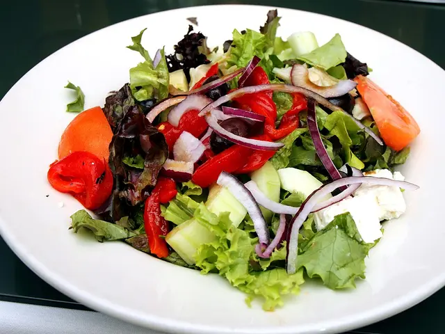 A plate of mixed green salad served at a restaurant table.