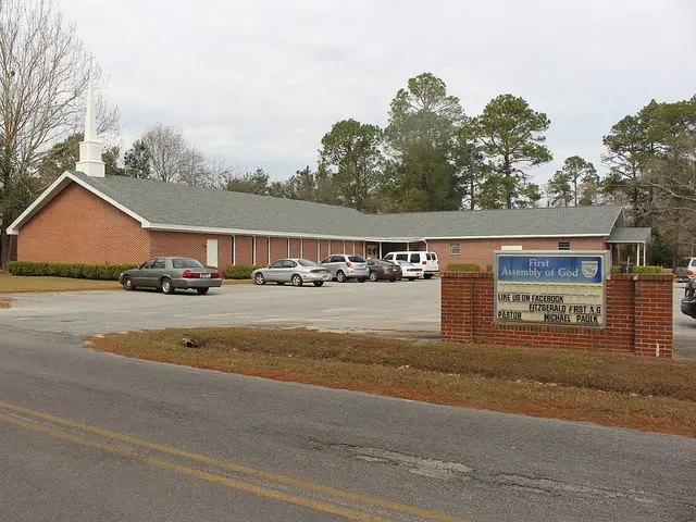 First Assembly of God Church in Fitzgerald, Georgia, a brick single-storey church with a white steeple and a parking lot in front.