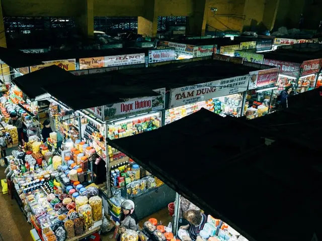Stalls of goods under a covered market roof at a grocery market in Da Lat, Vietnam