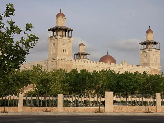 A mosque with domes and minarets behind a stone wall
