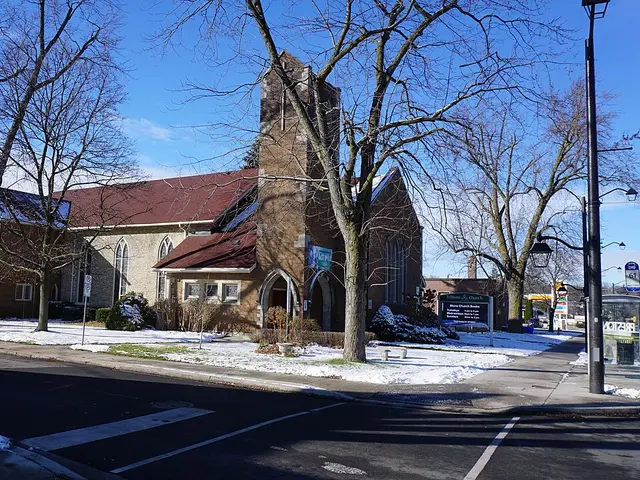 The exterior of a brick church building photographed in winter with snow on the ground.