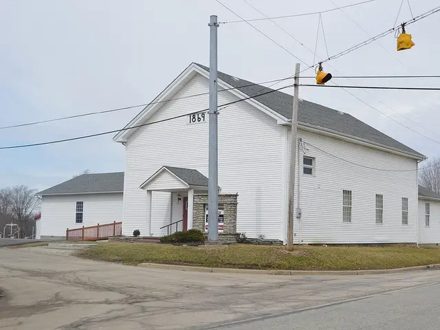 Exterior of the white wood-sided Family Worship Church building at a rural road junction in Blooming Grove, Indiana.