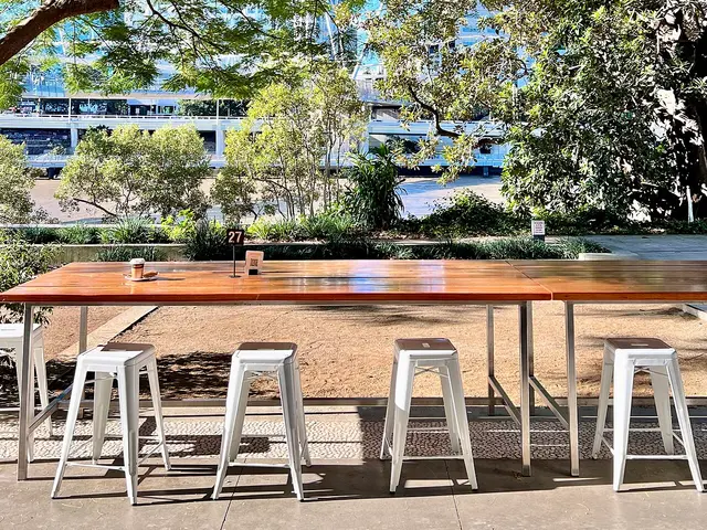 Casual dining area with timber tables and metal stools at a cafe in Brisbane, Australia.