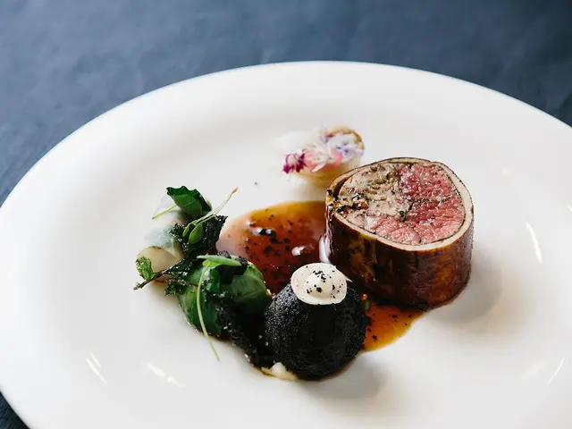 A competition-plated meat dish with sauce garnish on a white plate.