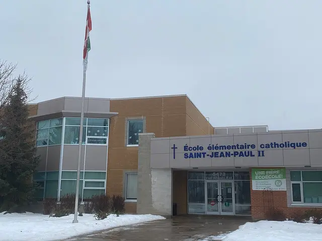The entrance of a Catholic elementary school in Ottawa, with a cross and the school's French name on the facade