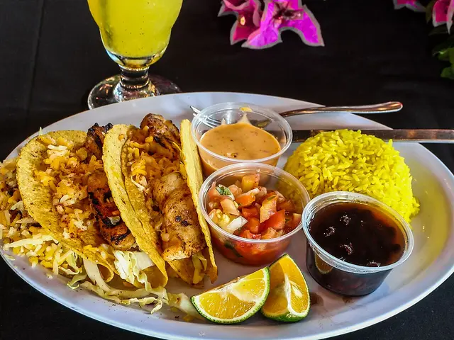 Fish tacos served with rice, salsa, and lemonade.