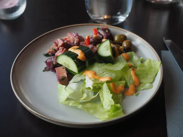 A plate of salad served as a starter at a restaurant table.