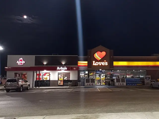 Love's Travel Stop convenience store and gas station lit up at night, seen from the fuel pumps
