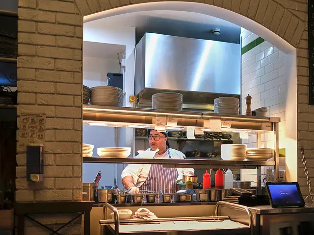 Kitchen staff preparing plates during restaurant service.