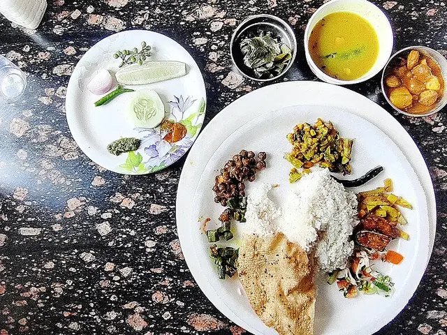 A regional Indian thali from Arunachal Pradesh with rice, vegetable dish, and papad.