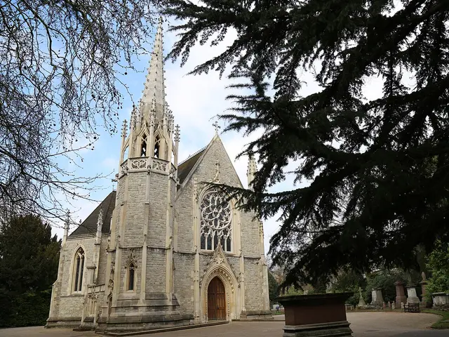 Exterior of the Anglican chapel at the City of London Cemetery and Crematorium, a Gothic Revival stone building with a tall spire and rose window.