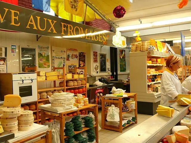 Cheese shop displaying many varieties of cheese in a market in Lille, France.