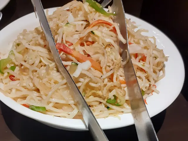 A plate of Chinese noodles served with rice.