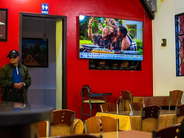 The interior of a restaurant in Loja, Ecuador, with a customer seated near the entrance.