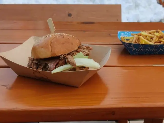 A hamburger served with a side of french fries on a plate.