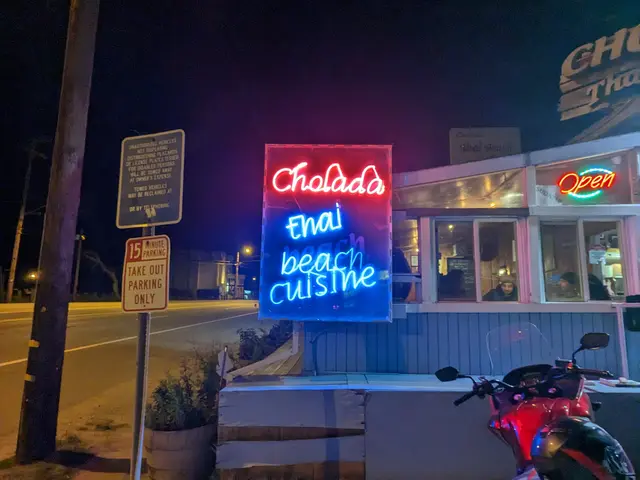 Evening exterior of Cholada Thai Restaurant with its neon sign in Malibu, California.