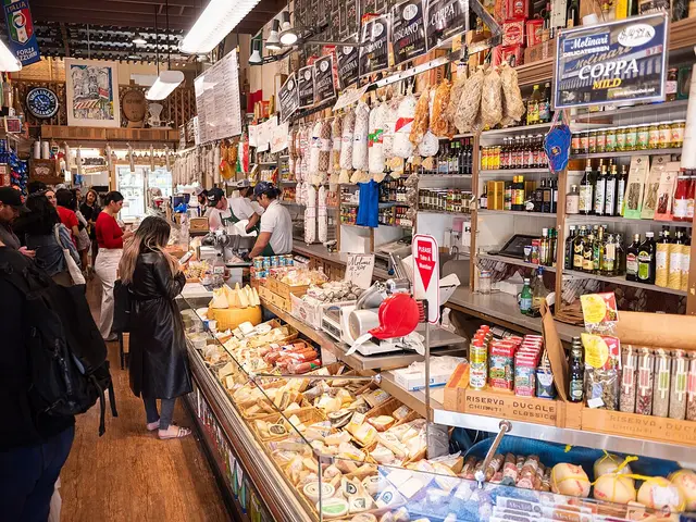 Interior of a delicatessen with cured meats hanging above shelves of specialty food products.