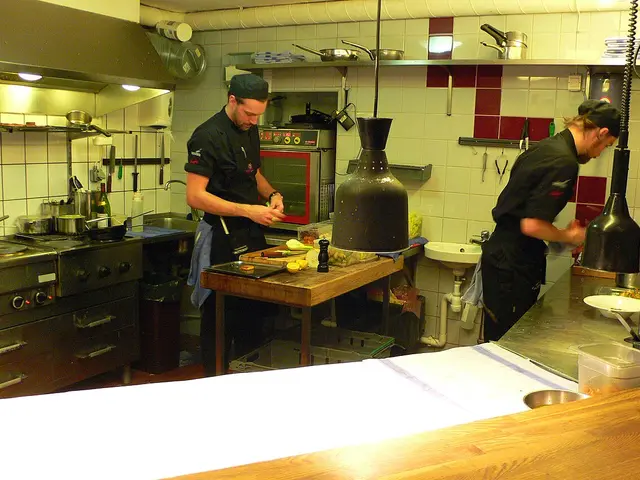 Chefs cooking at the open kitchen counter of a restaurant.