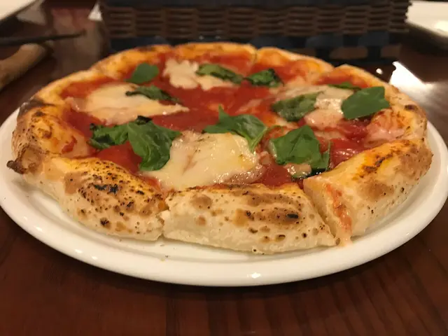 A margherita pizza topped with tomato sauce, mozzarella, and basil.