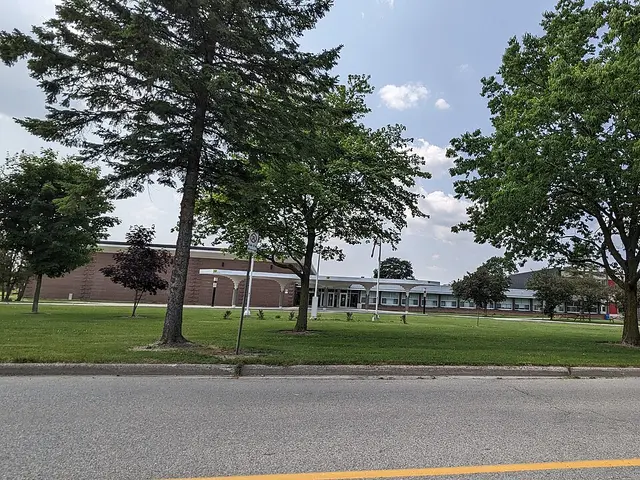 The low brick building of Stratford District Secondary School, a public high school in Ontario, seen across its front lawn.