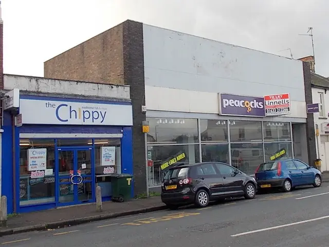 Storefront of a fish and chip shop next to a vacant retail unit.