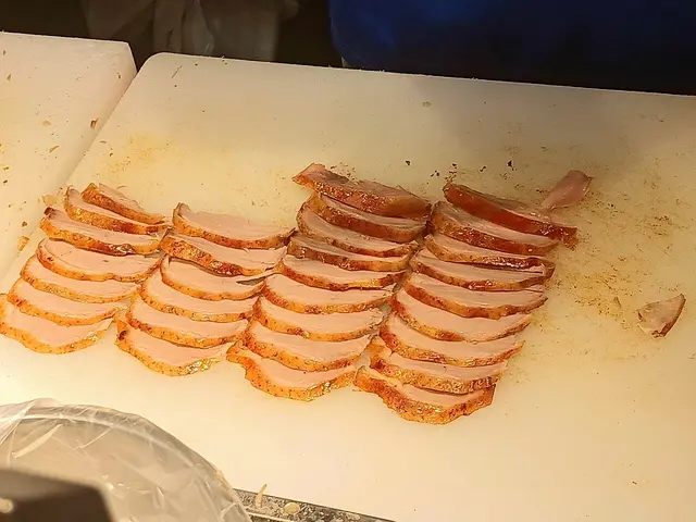 Sliced Peking duck arranged on a serving plate.