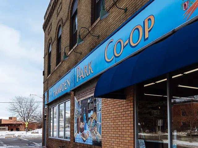 Exterior of the Hampden Park Co-Op, a natural foods grocery store, with a blue awning and brick facade.