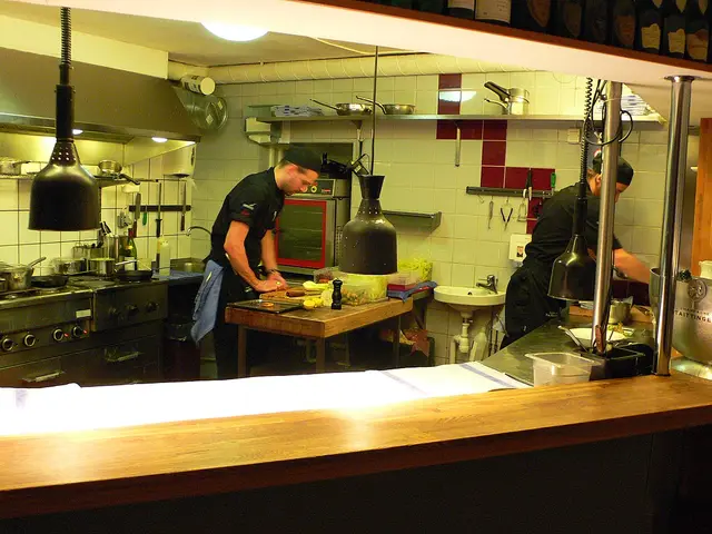 Chefs working in the open kitchen of a restaurant.