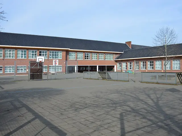 The brick exterior and paved schoolyard of Campus Kompas secondary school in Wetteren, Belgium.