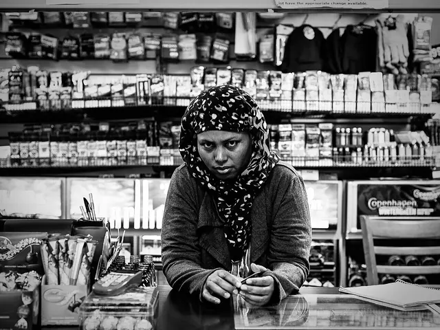 A shopkeeper standing behind the sales counter of a convenience store in Minneapolis.