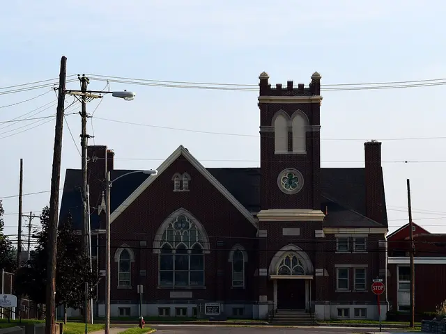 Exterior of Saint John Lutheran Church, a brick church building with a steeple in Piqua, Ohio, photographed at night.