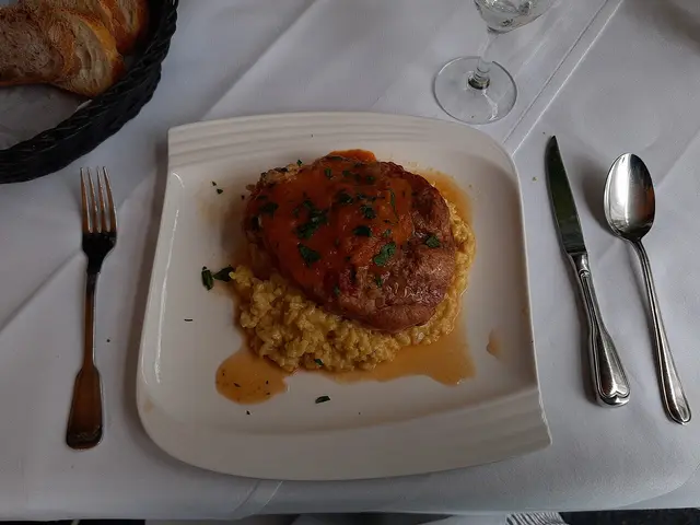 A plate of osso buco served on saffron risotto.