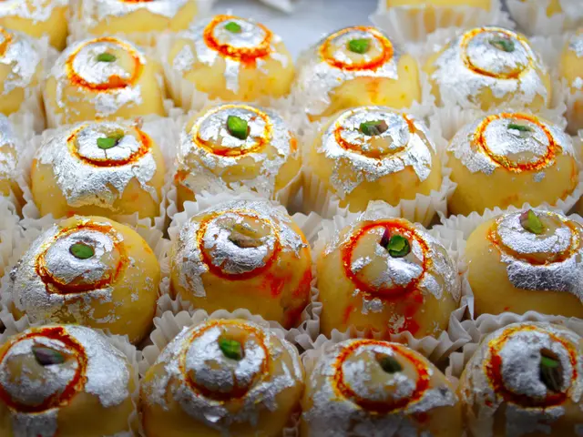 A tray of Indian sweets garnished with edible silver foil, served at a restaurant.