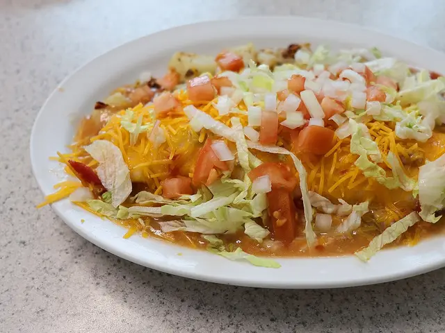 A breakfast burrito smothered in red chile sauce.