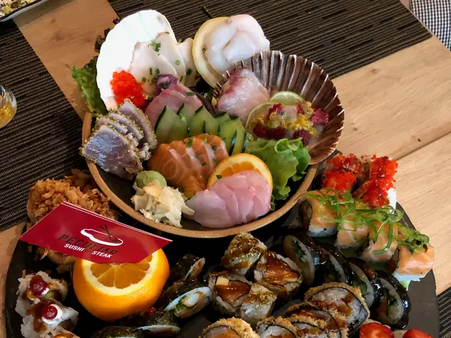 A platter of mixed sushi rolls and nigiri served at a restaurant.
