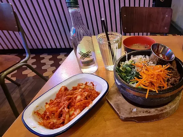 A bowl of Korean bibimbap served with kimchi.