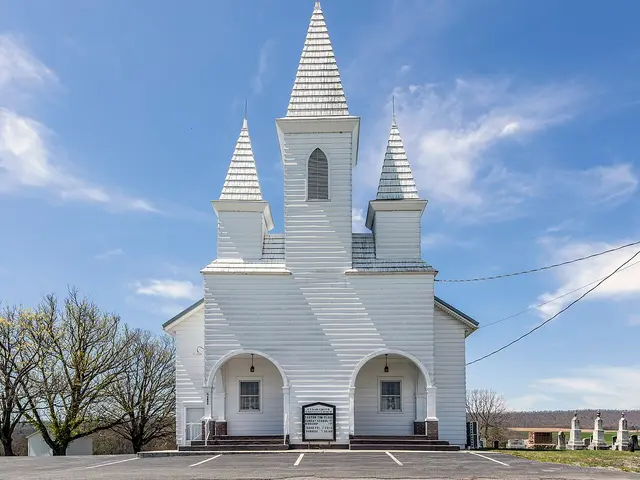 The exterior of a small white wooden church building in a rural setting.