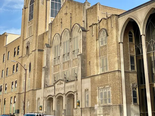Exterior of First Baptist Church, a Gothic Revival stone church building with a green spire in Tulsa, Oklahoma.